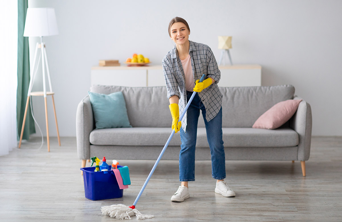 pretty-young-lady-wiping-floor-with-mop-doing-hous-SJBBD47